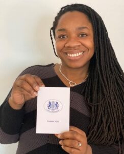 Danielle Bridge holding a thank you card from the Lord Lieutenant of Cambridgeshire